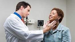doctor checking thyroid glands of female patient