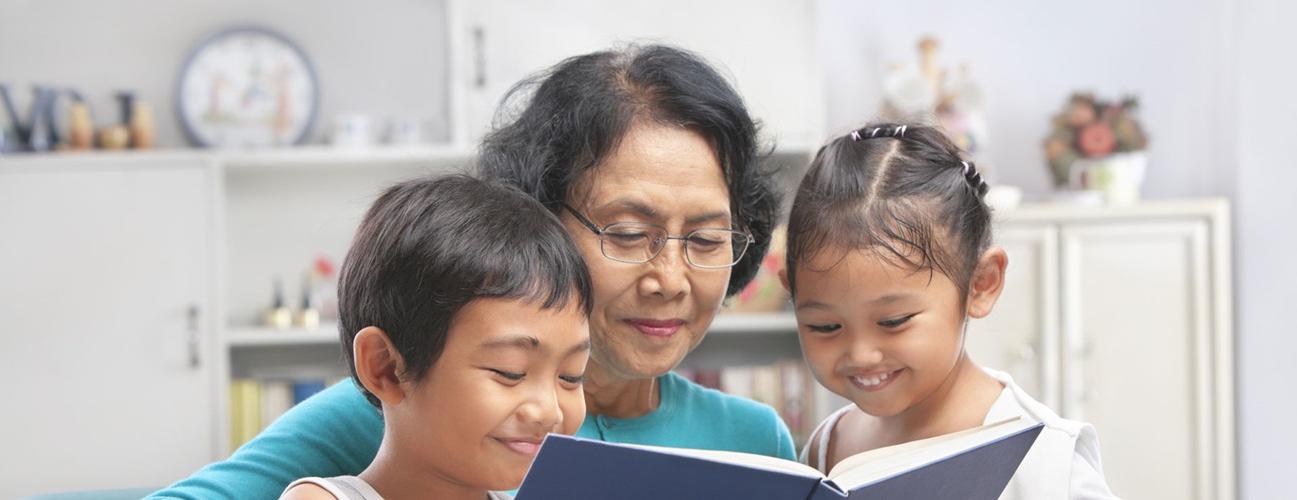 一位戴眼镜的祖母给她的孙子们读书