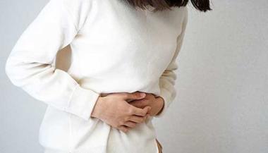 Woman clutching her stomach in pain.