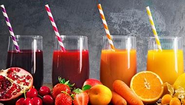 Assortment of fresh fruit and vegetable juices in rainbow colors.