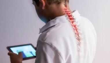 一个男孩前倾身子玩手机游戏时，脊椎显示出紧张