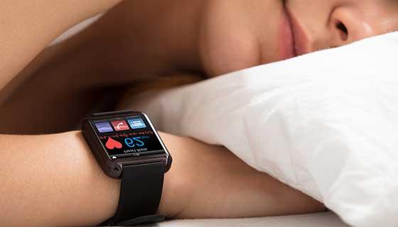 A person sleeping with a smart watch tracking their sleep